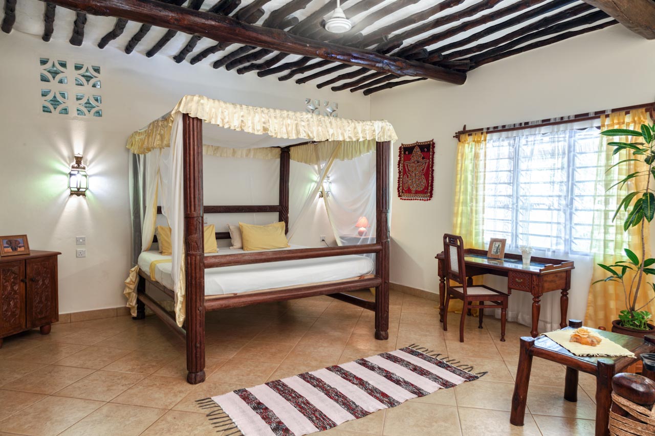 Villa Madagaskar · bedroom with carved canopy bed and lanterns