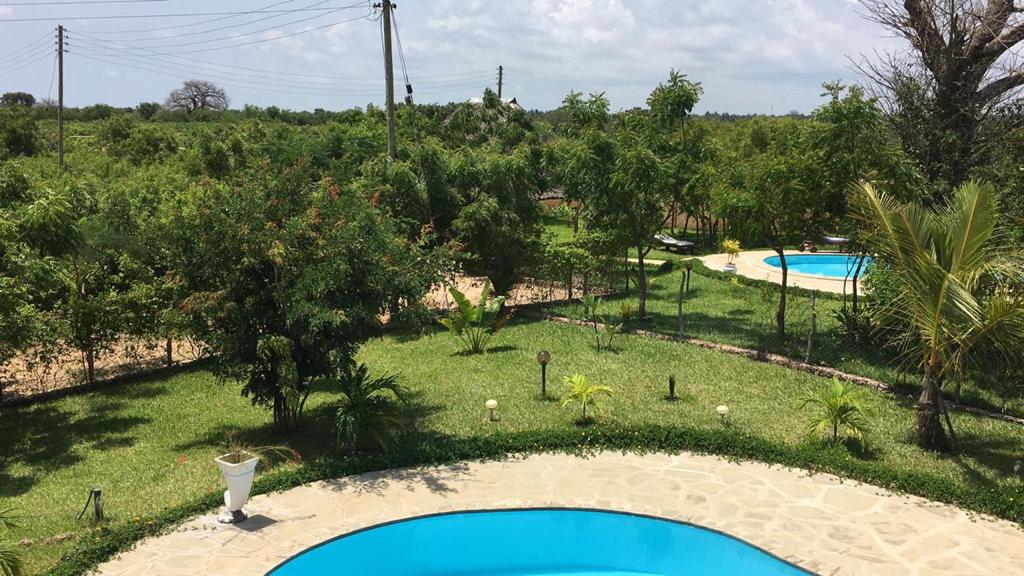 Asili Yetu — elevated view of two pools set within landscaped tropical gardens