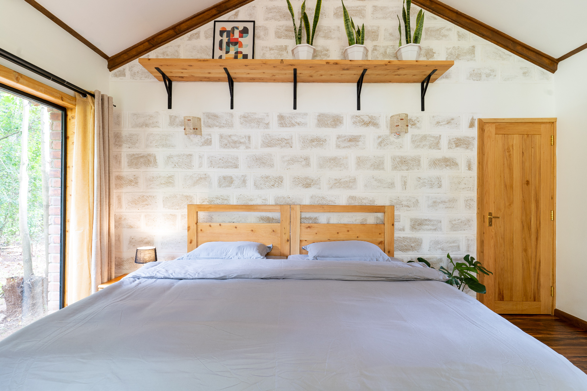 Jungle Oasis — bed with brick accent wall and timber beams
