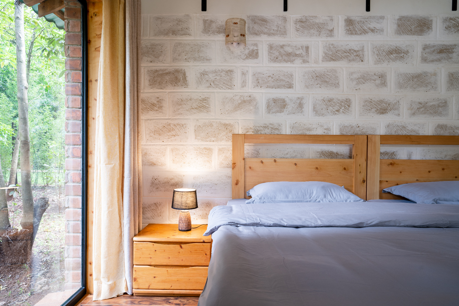 Jungle Oasis — bedside detail with brick wall and forest view