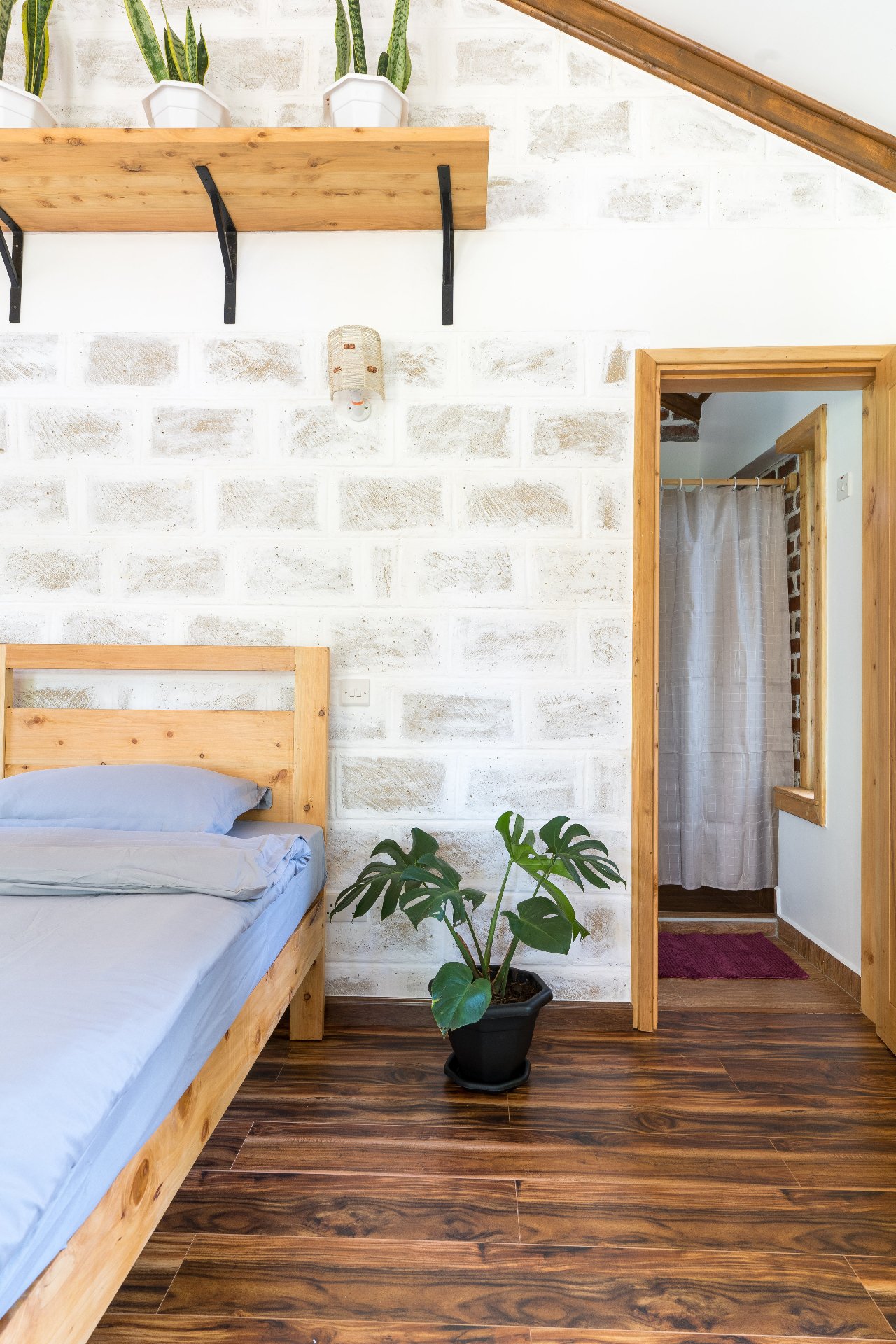 Jungle Oasis — bedroom with brick wall and en-suite bathroom